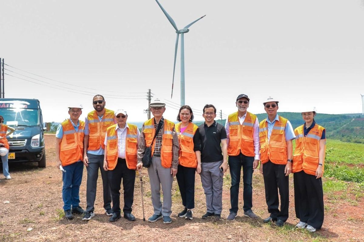 The visiting group beneath a turbine — Super Energy wind farm