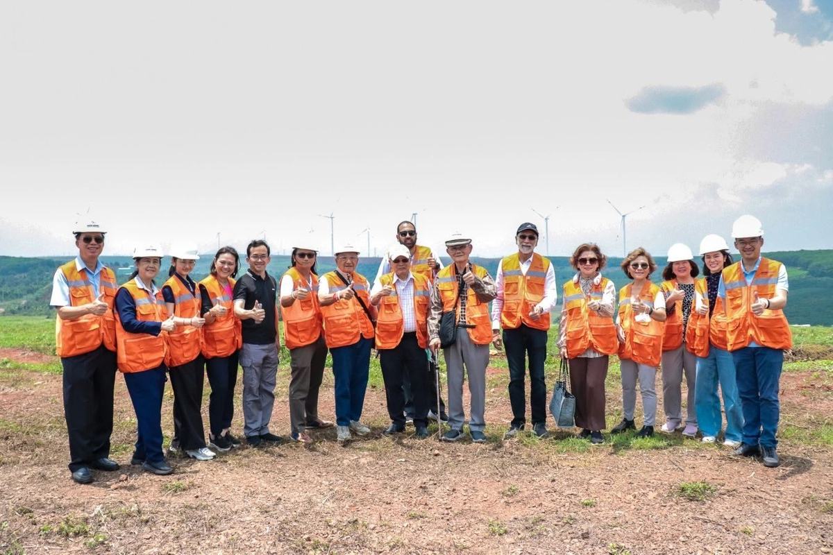 The visiting group on the ridge, turbines behind